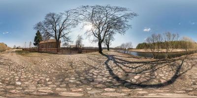 panorama hdri esférico sem costura completo vista de ângulo de 360 graus na estrada de cascalho perto da casa de tijolos na vila perto do rio em projeção equirretangular, conteúdo de realidade virtual vr pronto para ar foto