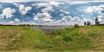 panorama hdri esférico sem costura completo vista de ângulo de 360 graus na costa de grama do enorme lago ou rio em dia ensolarado de verão e tempo ventoso com belas nuvens em projeção equirretangular, conteúdo vr foto