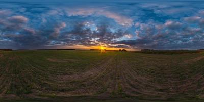 panorama hdri esférico completo sem costura vista de ângulo de 360 graus entre campos no pôr do sol da noite de verão com incríveis nuvens vermelhas alaranjadas azuis em projeção equirretangular, pronta para realidade virtual vr ar foto