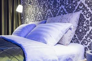 cama de casal com almofadas no interior do quarto moderno em loft em estilo de cor brilhante de apartamentos caros em luz neon foto