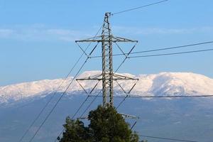 poste elétrico e fios transportando corrente de alta tensão foto