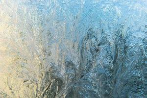 janela de inverno congelado com textura de padrão de geada de gelo brilhante. símbolo de maravilha de natal, abstrato. extremo norte de baixa temperatura, neve de gelo natural em vidro gelado, clima frio de inverno ao ar livre. foto