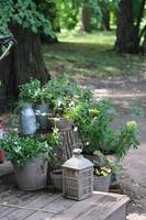 composição retrô vintage de jardim com flores e lanterna de vela. decoração de quintal, jardinagem e design de casa. tamanho vertical. foto