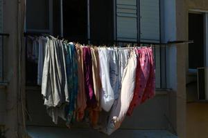 linho lavado seca na rua do lado de fora da janela da casa. foto