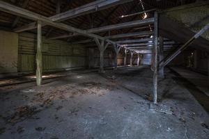 dentro do hangar em decomposição de madeira arruinado escuro abandonado com colunas apodrecidas foto