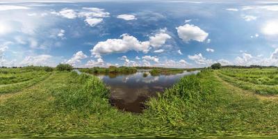 panorama esférico hdri vista de ângulo de 360 graus na costa de grama do enorme lago ou rio em dia ensolarado de verão e tempo ventoso com belas nuvens em projeção equirretangular, conteúdo vr foto