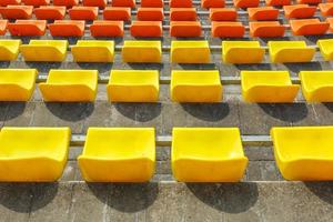 fileiras multicoloridas de assentos de plástico no estádio foto