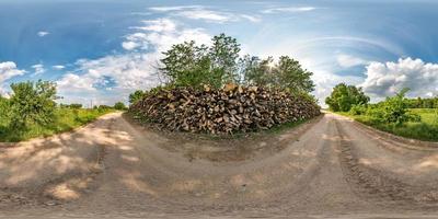 panorama hdri esférico sem costura completo vista de ângulo de 360 graus na estrada de cascalho perto de lenha em dia de verão com nuvens impressionantes em projeção equirretangular, para conteúdo de realidade virtual vr ar foto