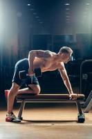 fisiculturista muscular atleta treinando de volta com halteres no ginásio