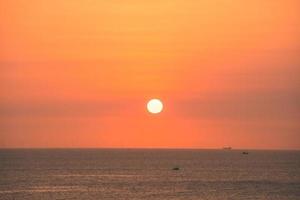 bela paisagem de praia do sol, natureza exótica ilha tropical, céu amarelo vermelho colorido, silhueta de navio, reflexo de brilho do sol dourado, férias de verão. céu nuvem cinematográfica. foto