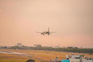 cidade de ho chi minh, vietnã - 12 de fevereiro de 2022 avião sobrevoa áreas urbanas preparando o pouso no aeroporto internacional tan son nhat e decola no aeroporto tsn foto