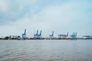 ho chi minh, vietnã - 19 de fevereiro de 2022 transporte para exportação, importação no porto de cat lai no rio sai gon, contêiner de carga de guindaste para barco, este porto é um grande serviço da indústria para o comércio foto