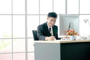 gerente masculino tomando notas no escritório em casa foto