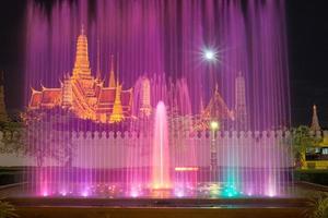 o templo de esmeralda de bangkok as capitais da tailândia no crepúsculo com o show de fontes coloridas. foto