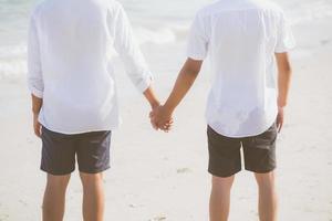 closeup casal gay asiático de mãos dadas juntos na praia com relaxar e lazer no verão, lgbt homossexual legal dois homem feliz e romântico em férias, conceito de amante do sexo de relacionamento. foto