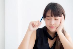 jovem escritora asiática sorrindo pensando a ideia e escrevendo no caderno ou diário com feliz no escritório, estilo de vida da garota asiática é sucesso, planejamento feminino de trabalho, educação e conceito de negócios. foto