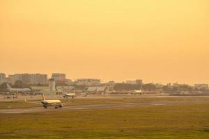 cidade de ho chi minh, vietnã - 20 de fevereiro de 2022 avião sobrevoa áreas urbanas preparando o pouso no aeroporto internacional tan son nhat e decola no aeroporto tsn foto