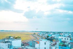 cidade de ho chi minh, vietnã - 12 de fevereiro de 2022 avião sobrevoa áreas urbanas preparando o pouso no aeroporto internacional tan son nhat e decola no aeroporto tsn foto