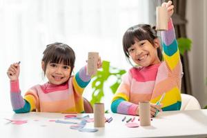 retrato de uma menina asiática cortando um papel em atividades na aula de diy na escola. foto