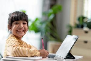 auto-isolamento de criança usando tablet para sua lição de casa, criança usando tablet digital pesquisando informações na internet durante o bloqueio covid 19, educação em casa, distância social, educação on-line de e-learning