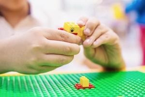 menino joga quebra-cabeça de bloco de brinquedo colorido para prática cerebral foto