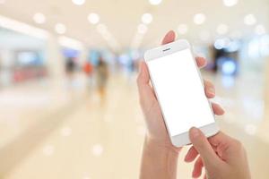 mão de mulher mostrando telefone inteligente com telas isoladas em um mercado ou loja de departamentos foto