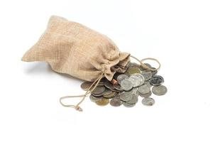 moedas de dinheiro no saco de serapilheira no fundo branco foto