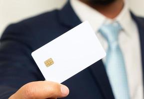 homem segurando segurando cartão de crédito em branco foto