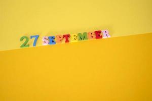 23 de setembro em um fundo amarelo e papel com letras de madeira e números em cores diferentes. foto