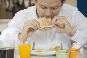 homem de negócios come o café da manhã americano em um hotel - as pessoas tomam um café da manhã no conceito de hotel foto