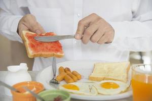 homem de negócios come o café da manhã americano em um hotel - as pessoas tomam um café da manhã no conceito de hotel foto