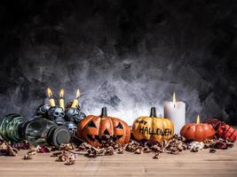 abóboras de halloween com luz de velas e caveiras em fundo escuro. foto
