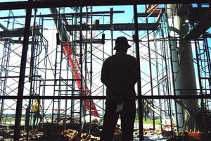 homem trabalhador em pé no canteiro de obras foto