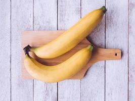 bananas na bandeja sobre o fundo da mesa de madeira. foto