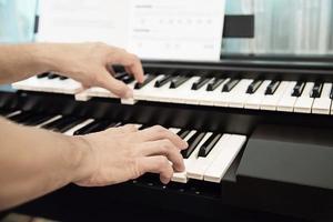 mão de homem toca teclado electone - pessoas com conceito de música foto