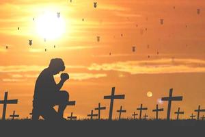 silhuetas de homens sentados e orando por bênçãos. conceito de esperança rezando pela salvação da perda da guerra. pare a guerra, não wa foto