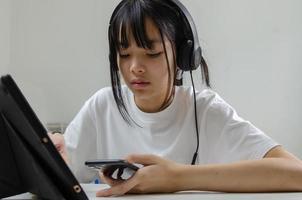 menina estudo aprendendo digital internet vídeo computador on-line laptop em casa. foto