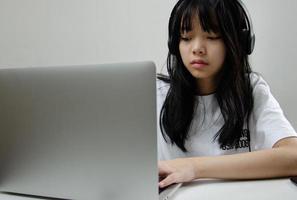 menina estudo aprendendo digital internet vídeo computador on-line laptop em casa. foto