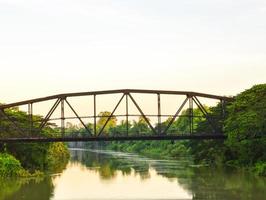 estrutura de ponte de aço preto no meio de um rio correndo foto