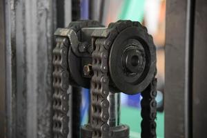 close-up da corrente do motor da máquina com parte da roda dentada da empilhadeira foto