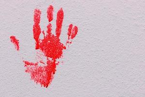 impressão sangrenta de uma mão sangrando em um fundo branco foto