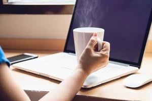 mulher trabalhando com computador com xícara de café no quarto de hotel - pessoas trabalhando conceito de estilo de vida foto