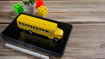 ônibus escolar em tablet para educação ou conceito de e-learning foto