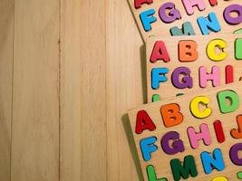 alfabeto de madeira multi cores na mesa para educação ou conceito de criança foto