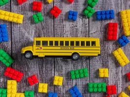 caixa de quebra-cabeça de plástico multicolorido e ônibus escolar para criança ou conceito de educação foto