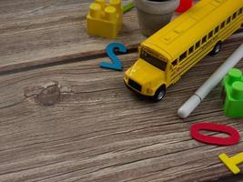 ônibus escolar na mesa de madeira para educação ou volta ao conceito de escola foto