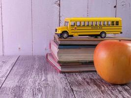 ônibus escolar na mesa de madeira para o conceito de educação foto