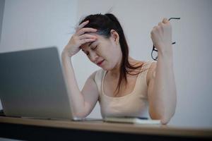 mulher sentindo dor depois de trabalhar no computador portátil por um longo tempo, conceito de síndrome de escritório
