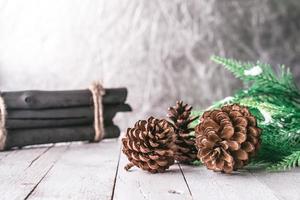 abeto com pinhas e lenha na mesa de madeira, fundo de decoração de natal foto