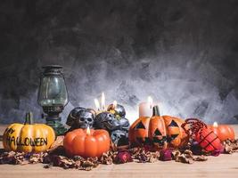 abóboras de halloween com luz de velas e caveiras em fundo escuro. foto